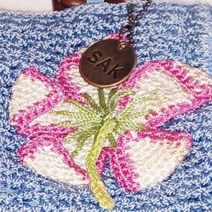 The Sak Blue knitted/woven bag with beautiful tropical flower on front.
